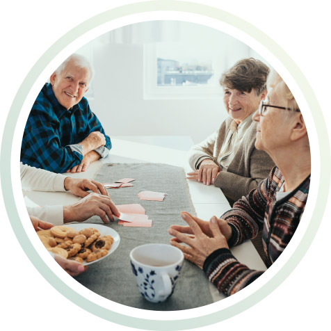 Eine Gruppe älterer Menschen sitzt am Tisch.