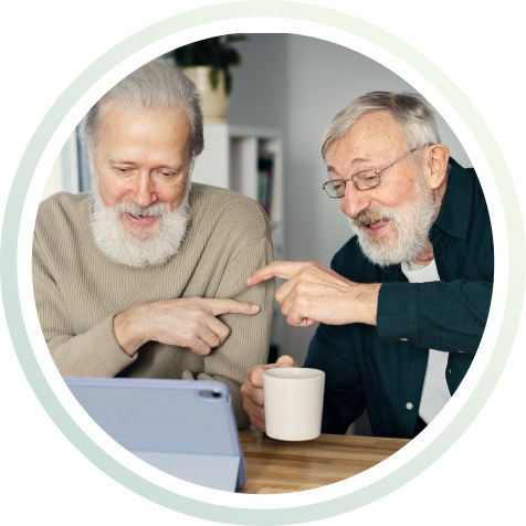 Zwei ältere Männer sitzen vor einem Tablet.