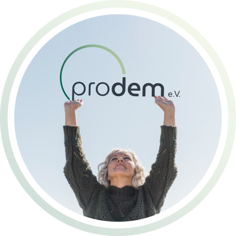 Eine ältere Frau hälst die Arme nach oben und stützt das PRO DEM Logo.