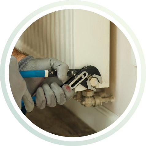 Die Heizung wird mit der Rohrzange repariert.